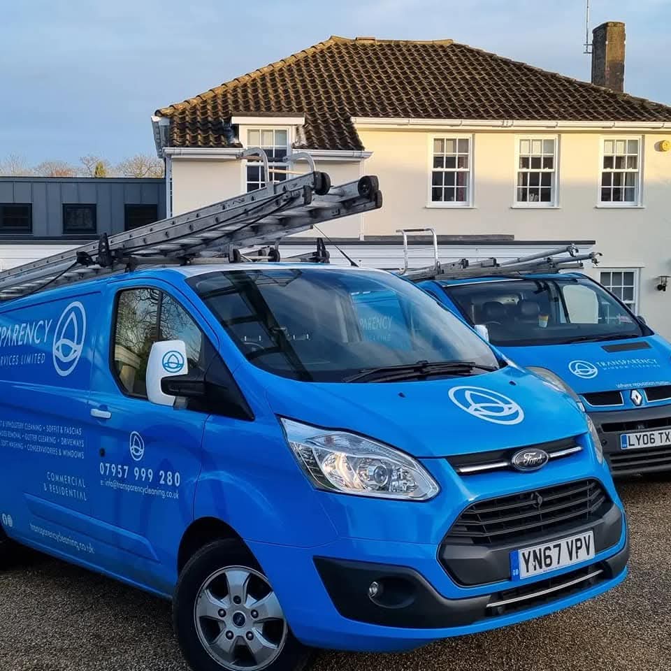 Two Transparency Cleaning vans parked outside a customer's home